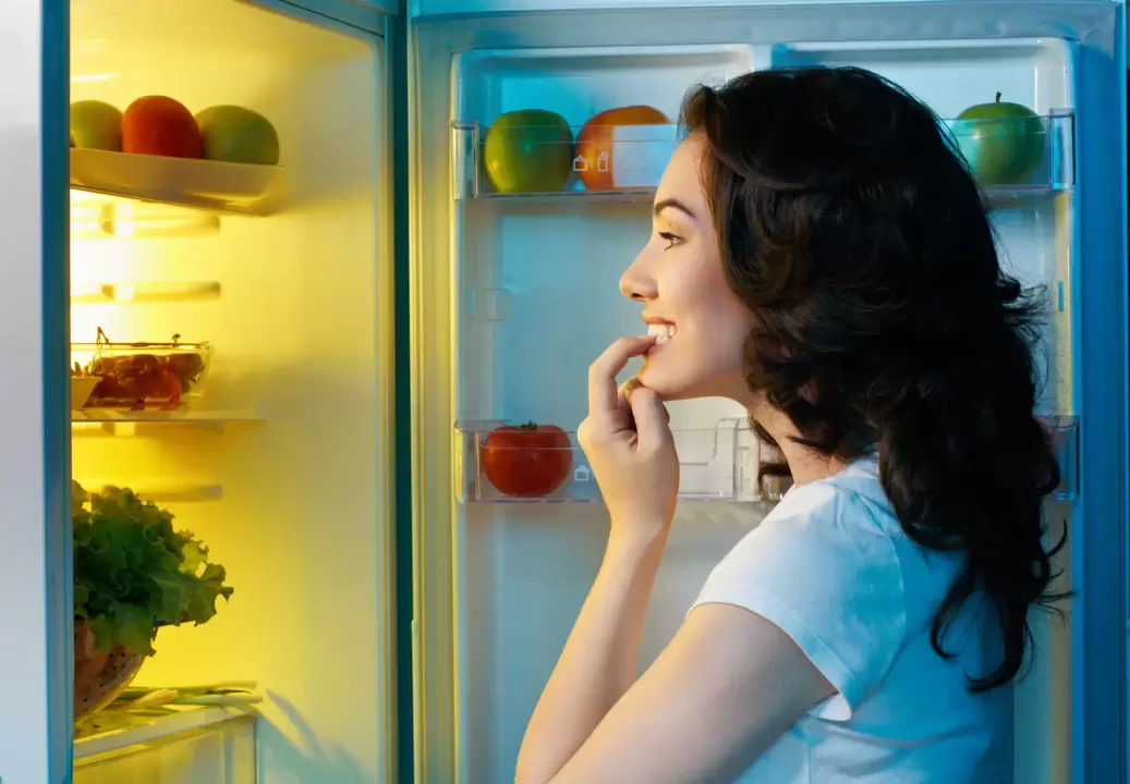 niña mira en el refrigerador durante la rápida pérdida de peso
